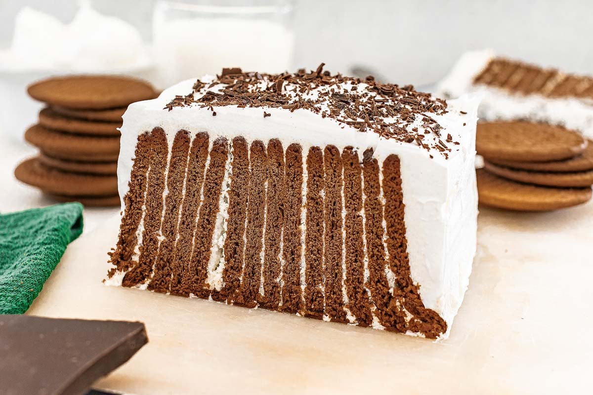 Slice of Chocolate Icebox Cake with chocolate cookie layers and whipped cream, topped with rich chocolate shavings.