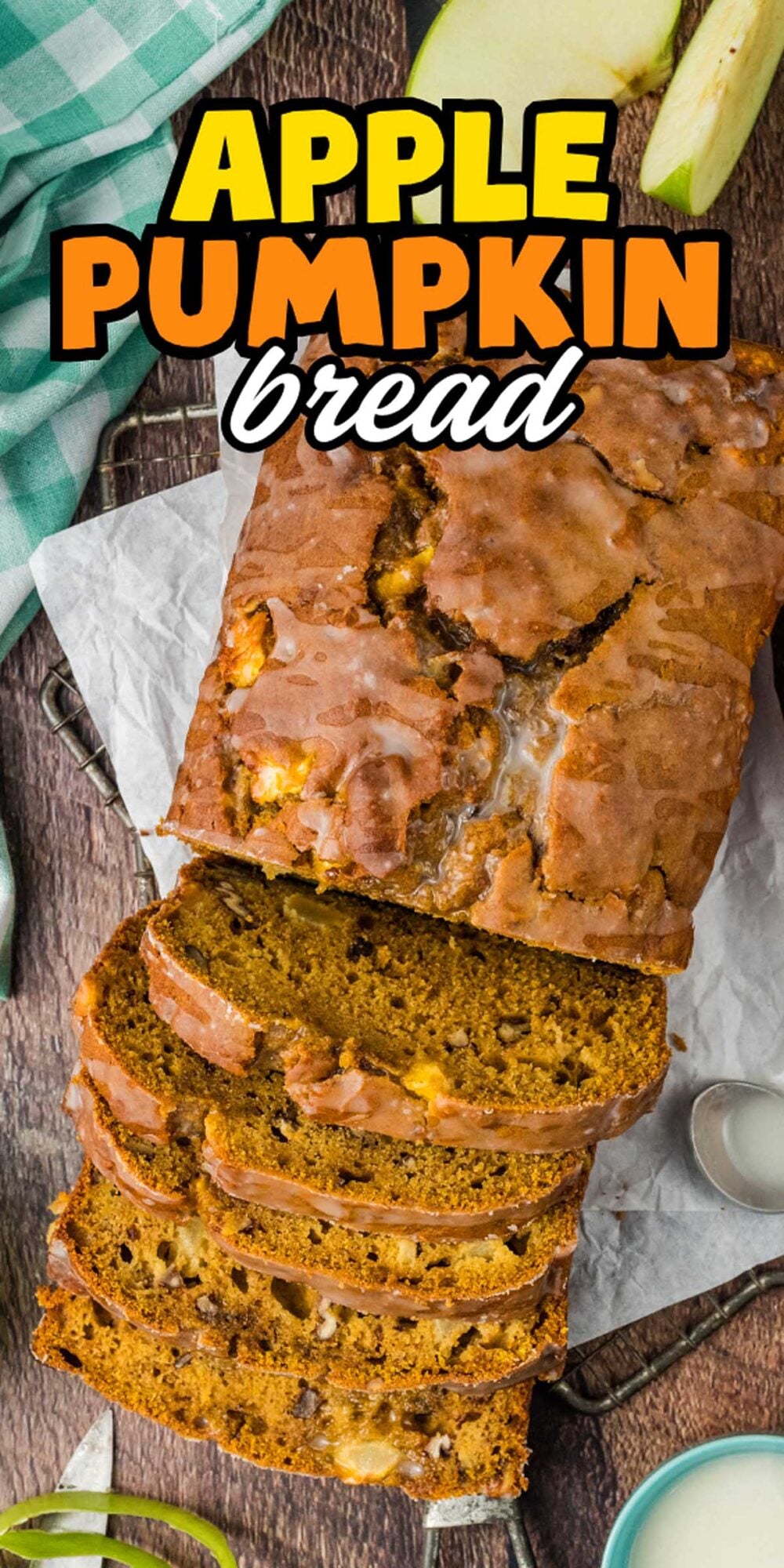 Sliced apple pumpkin bread with glaze sits on parchment, surrounded by fresh apple slices and a glass of milk.