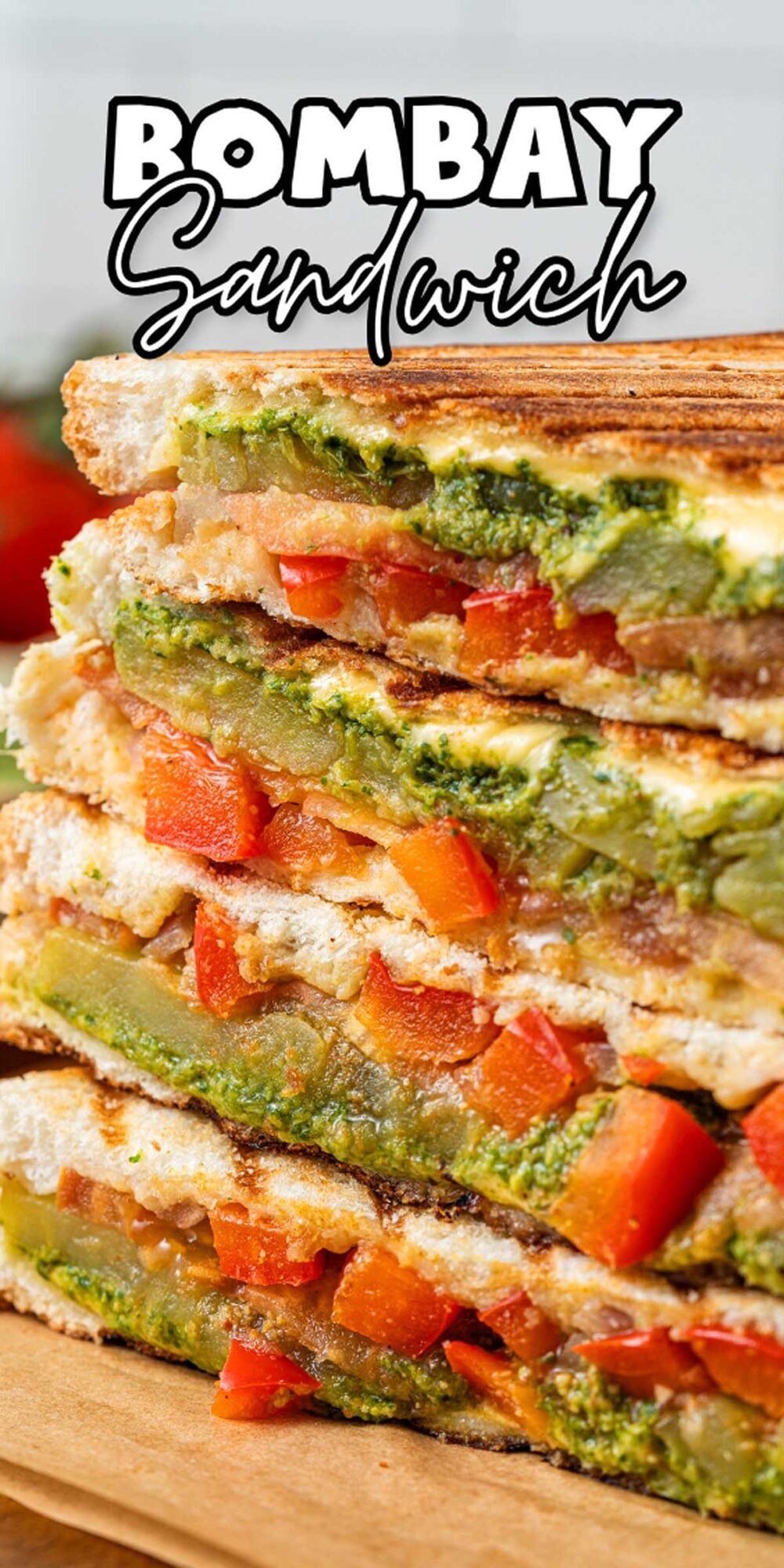 Stacked Bombay sandwiches with colorful veggies, tangy chutney, and melted cheese on toasted bread.