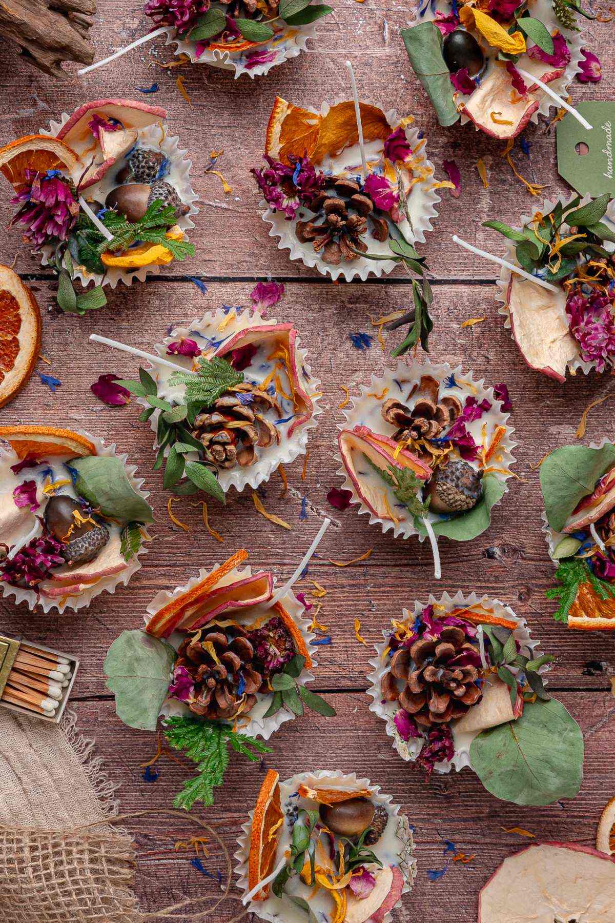 Colorful fire starters with pinecones, dried oranges, leaves, and flower petals arranged on a rustic table.