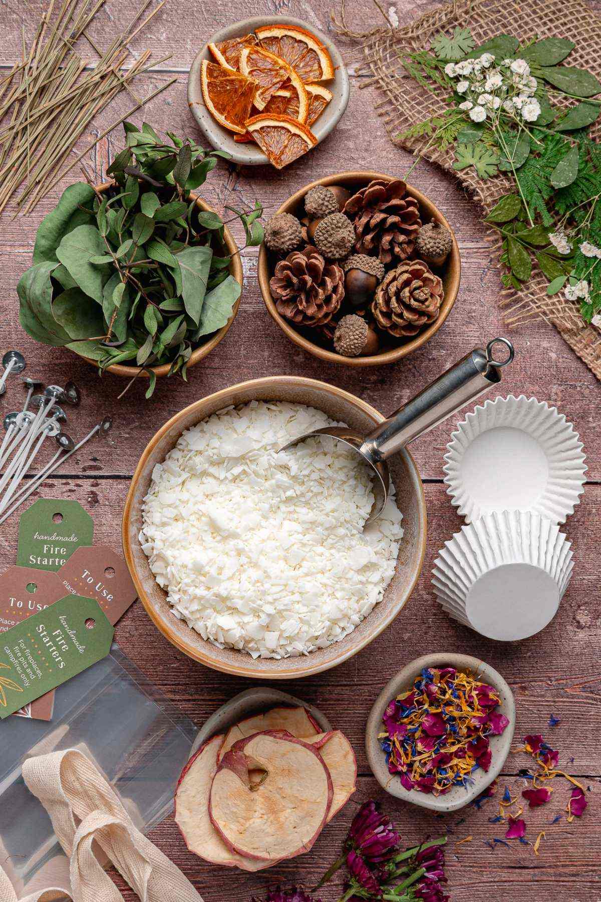 Bowl of wax flakes, pinecones, dried flowers, and craft supplies on a rustic wooden table.