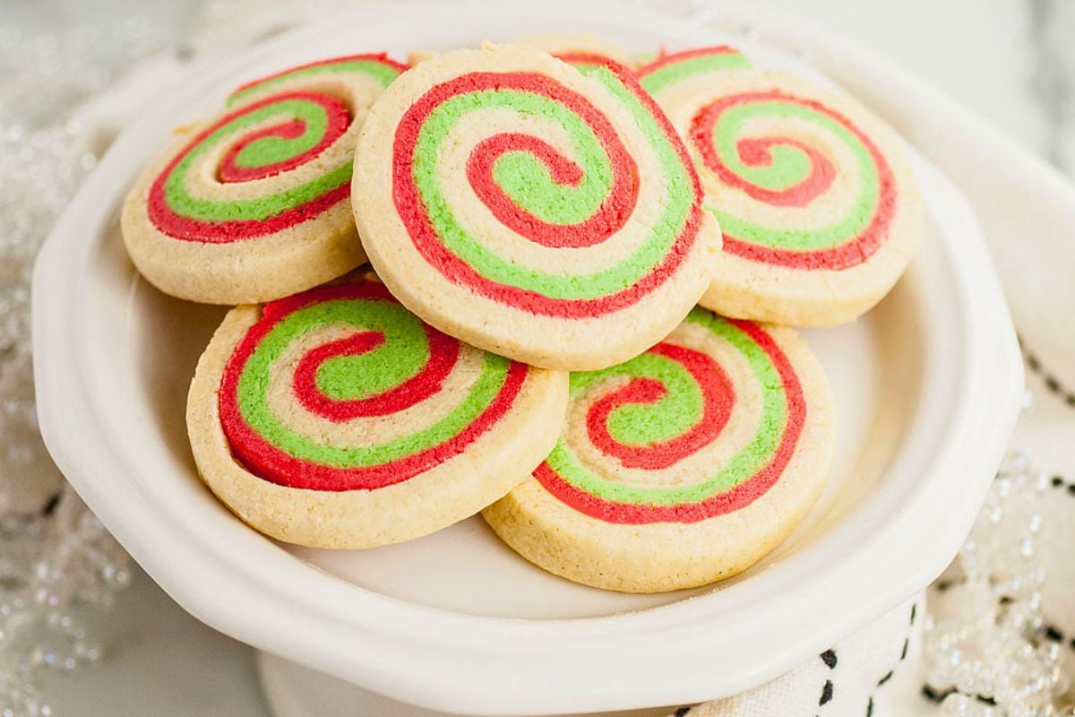Plate of round sugar cookies with red and green spiral patterns, arranged in a stack on a white dish—a delightful example of easy cookies that are as fun to make as they are to eat.