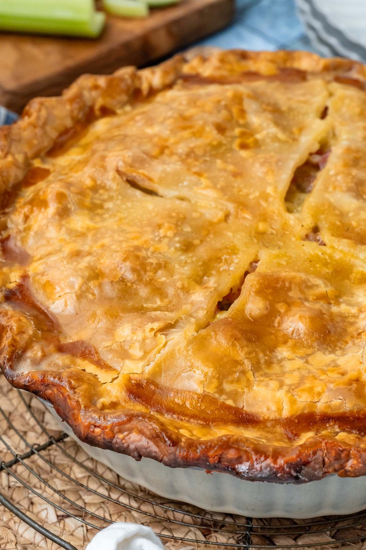 A golden-brown baked pot pie in a white dish.