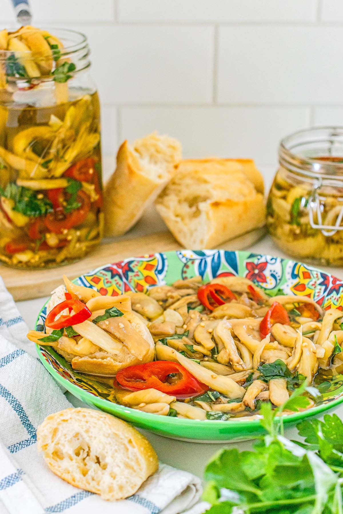 A colorful bowl of pickled Italian eggplant, served with crusty bread.