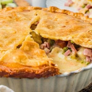 A baked ham and vegetable pot pie with a golden, flaky crust.