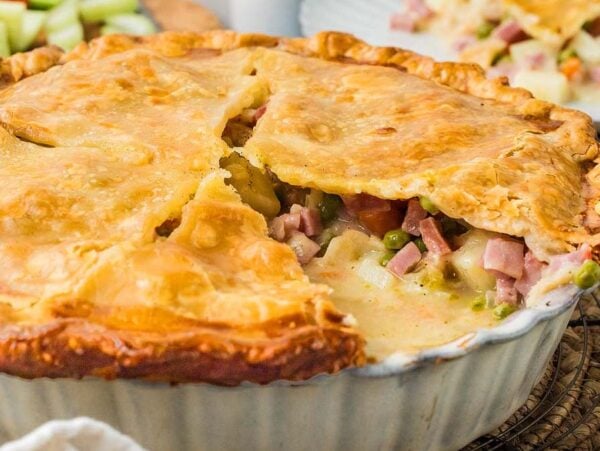 A baked ham and vegetable pot pie with a golden, flaky crust.