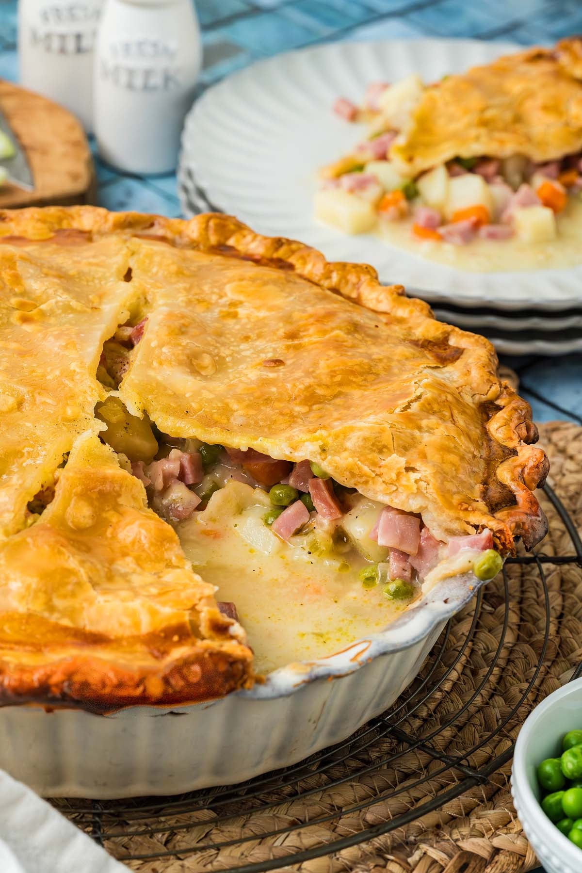 A ham and vegetable pot pie with a golden crust in a baking dish.