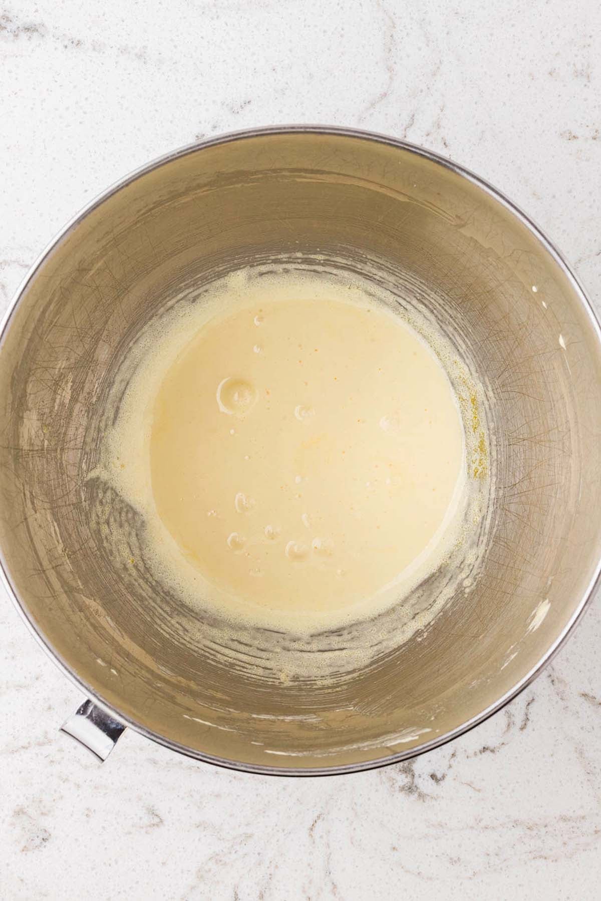 A smooth, pale yellow mixture in a metal mixing bowl.